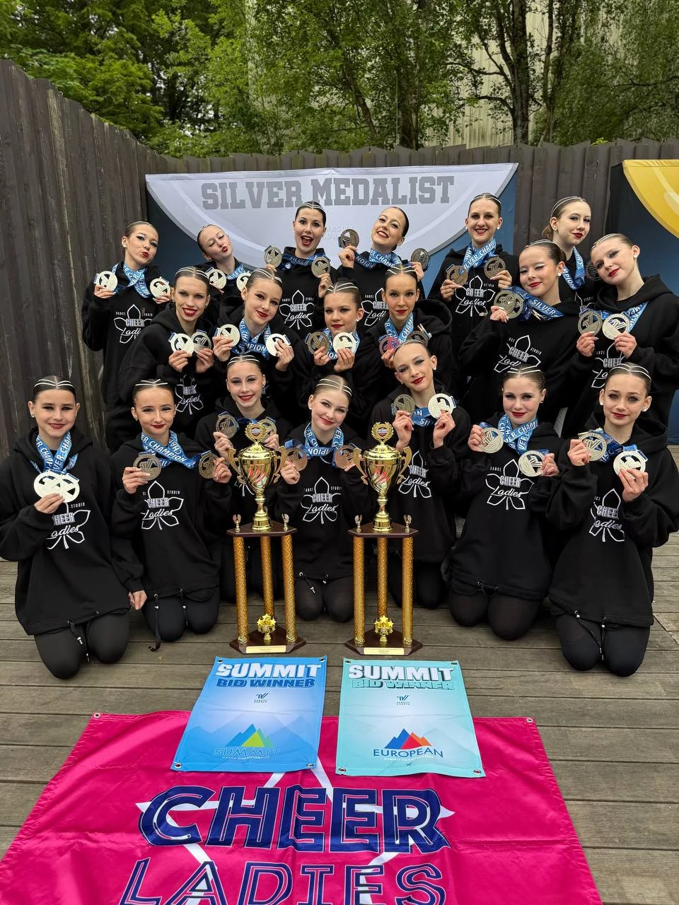 CheerLadies silver medalists in Düsseldorf with trophies and Summit BID Winner banners